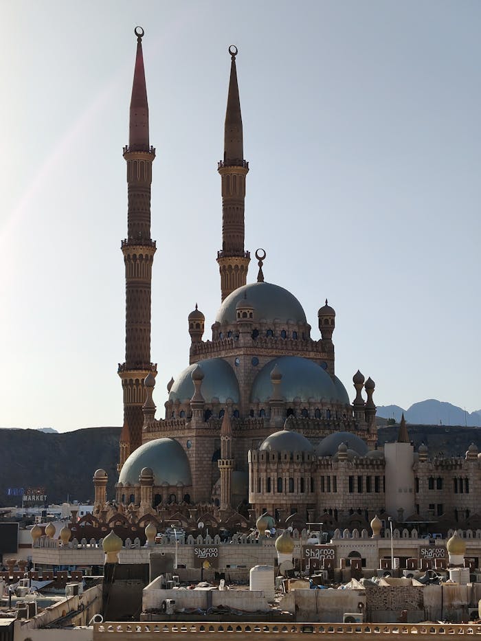 Stunning view of Al Sahaba Mosque in Sharm El Sheikh, Egypt, with blue domes and minarets at sunrise.